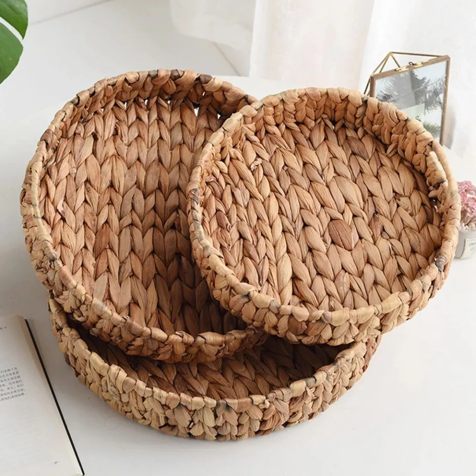 Set of three round hand-woven water hyacinth trays, neatly stacked, made from natural, eco-friendly materials.