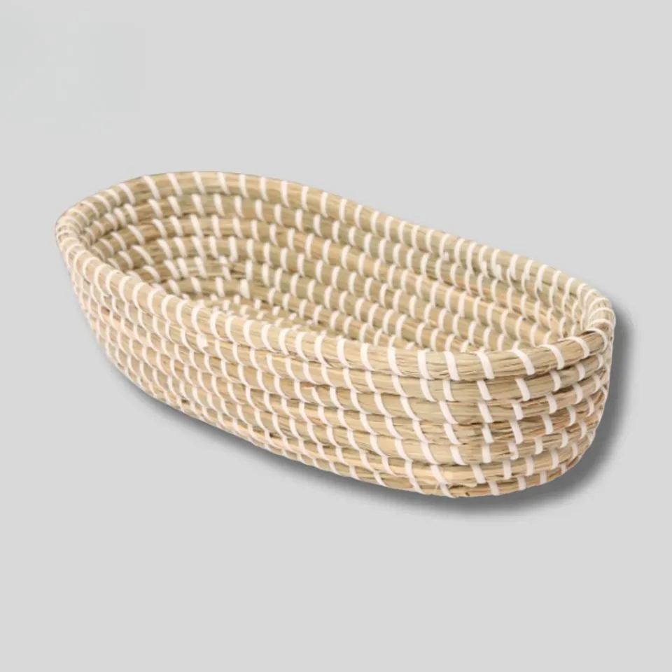 Handwoven oval seagrass bread basket with white rim accents, premium natural craftsmanship.