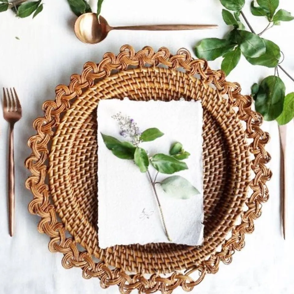 Handwoven rattan charger plate with intricate scalloped edge, showcasing natural texture and eco-friendly craftsmanship for sustainable tableware manufacturing.