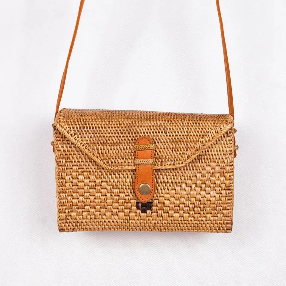 Square crossbody rattan handbag with leather flap closure, handmade by Ethical Handicraft Manufacturer (EHM).