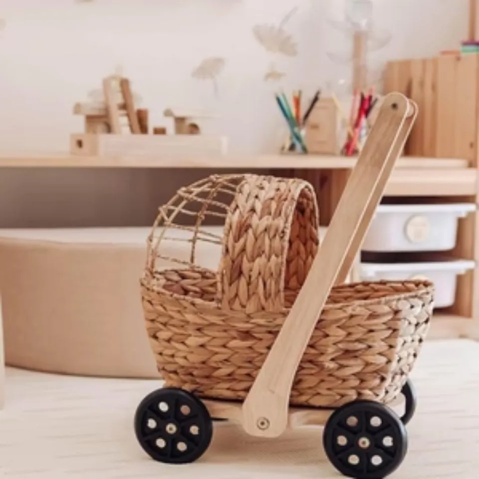 Handwoven water hyacinth doll stroller with wooden handle, rubber wheels, and breathable canopy – natural role-play toy.