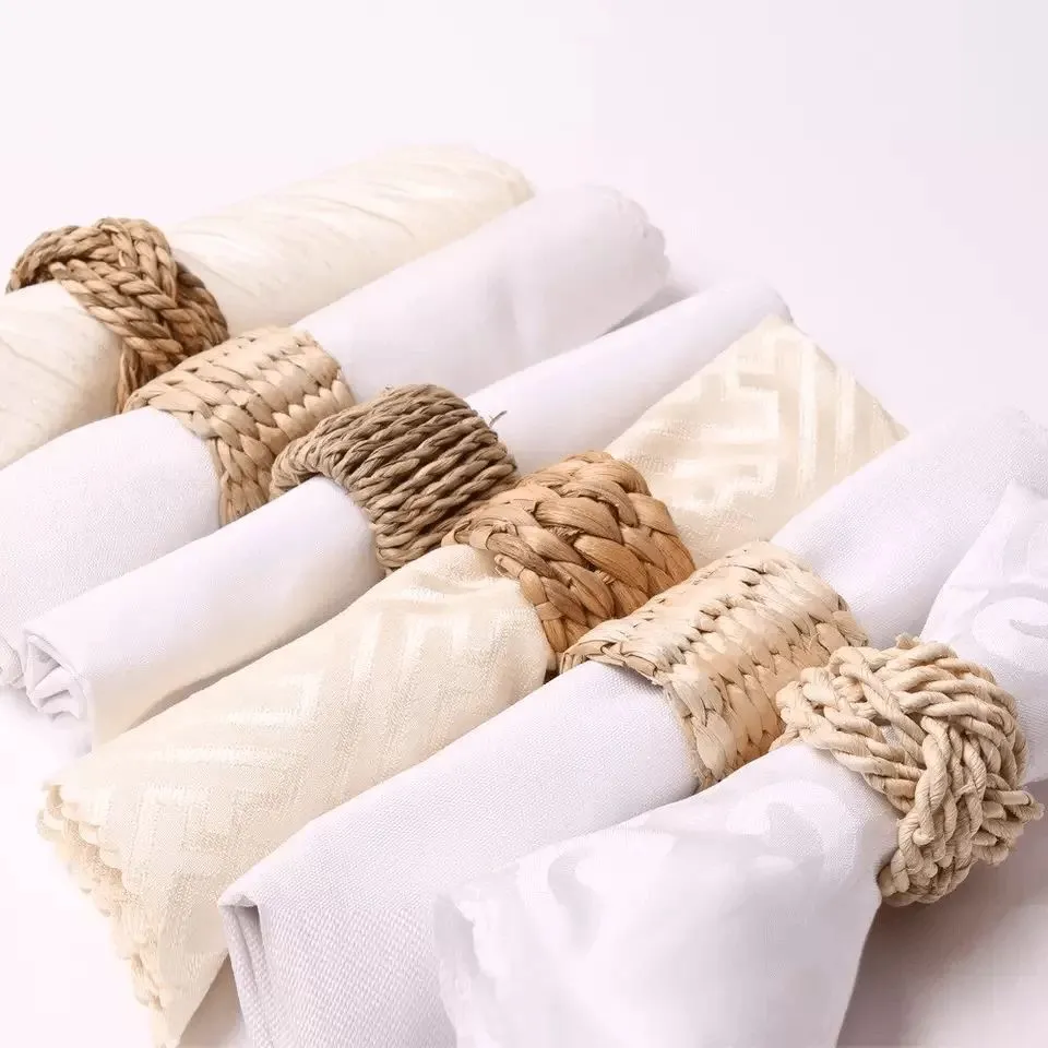 Two-tone Water Hyacinth and Seagrass Napkin Ring with alternating natural materials, wrapped around a folded white napkin – EHM’s blended textile creation.